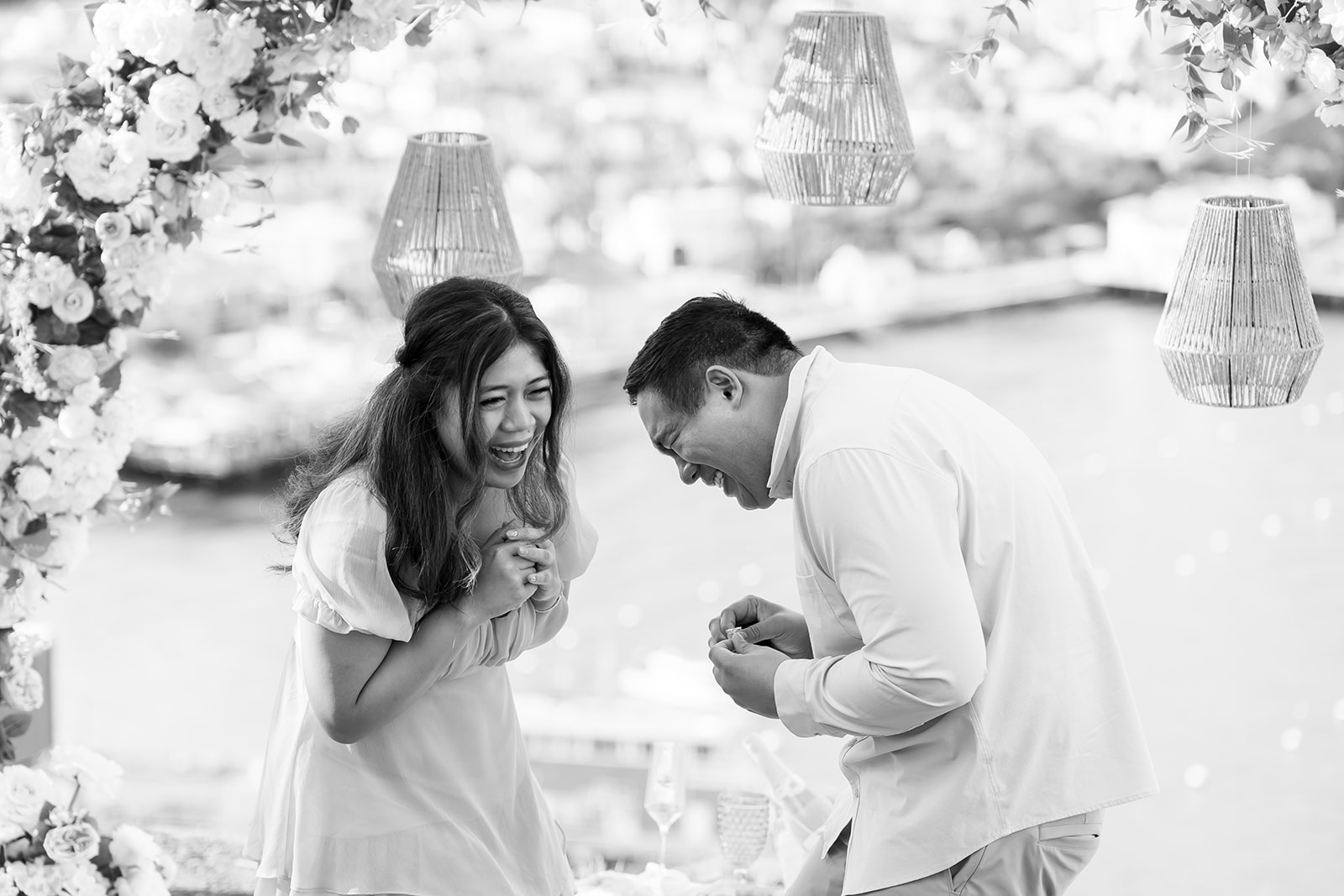 Black and white candid photo of a couple laughing during their Catalina Island proposal.