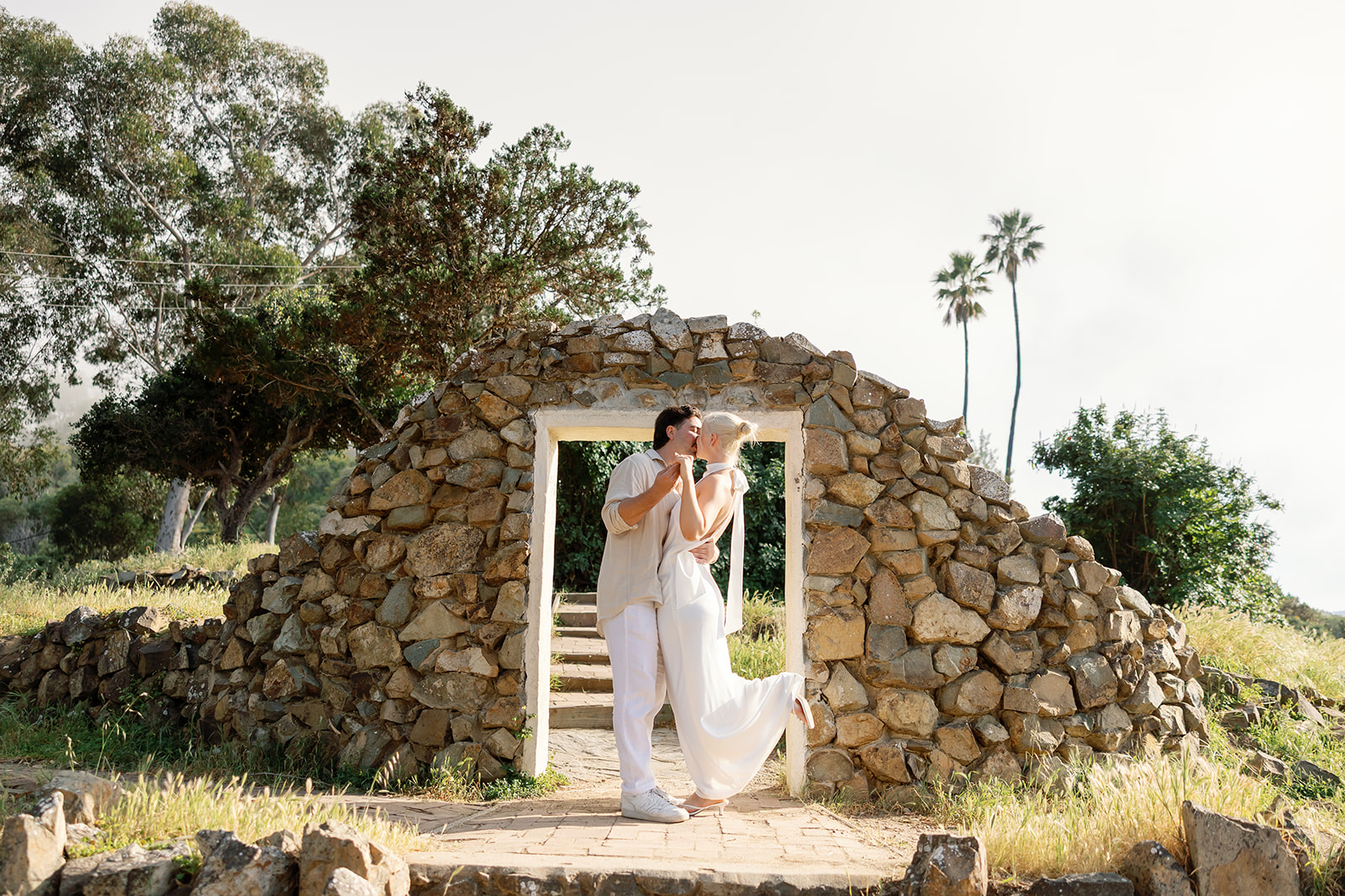 Catalina Island engagement photos in front of a stone structure. 