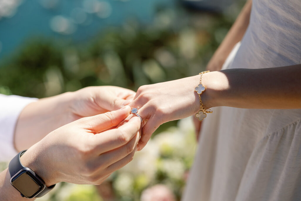 Man placing a ring on his fiancés finger.
