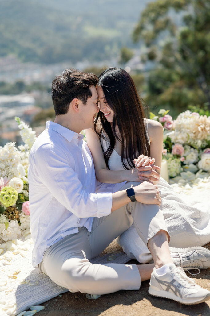 Couple sitting together on a blanket after their proposal.
