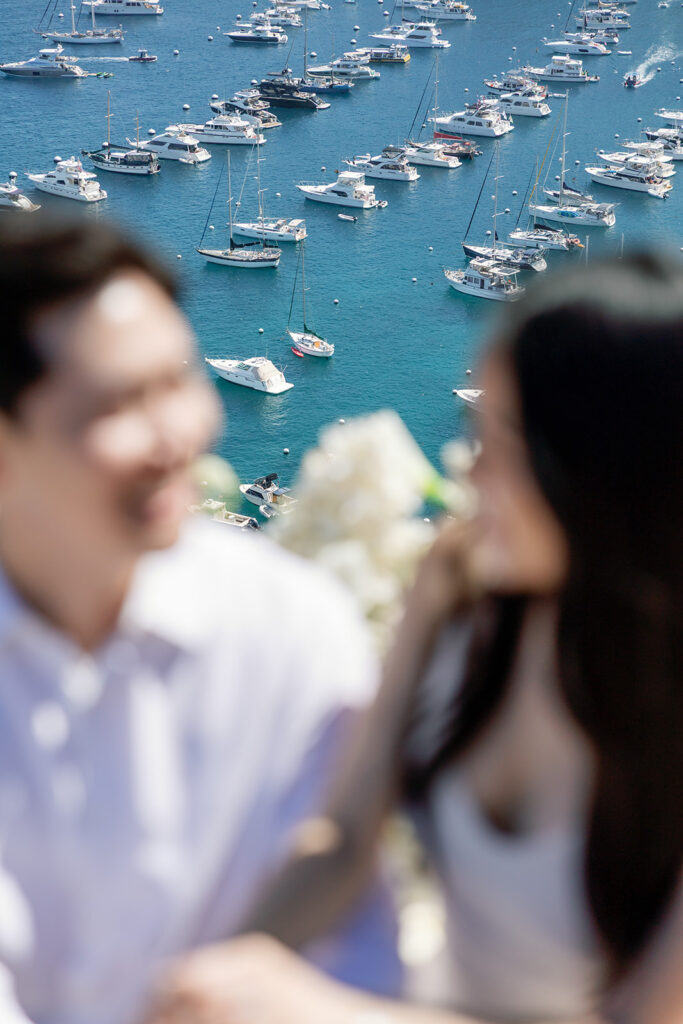 Couple sitting with views of Catalina Island harbor area behind them.
