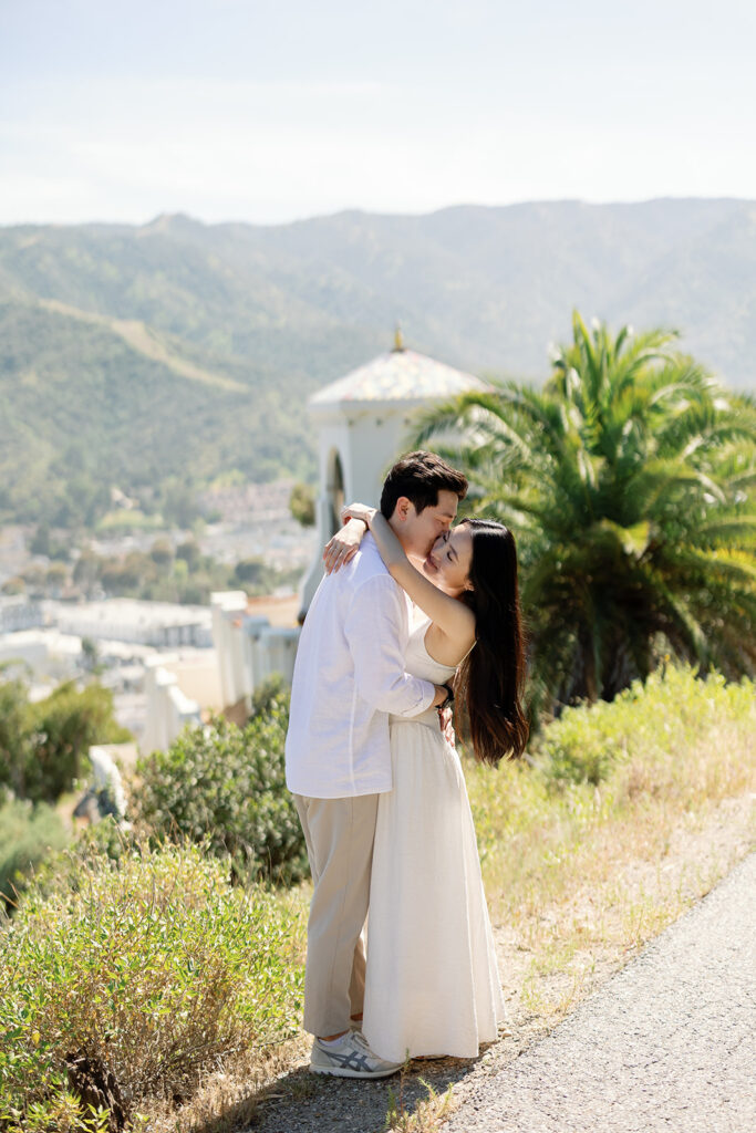 Man kissing his fiances cheek during their Catalina Island engagement photos.