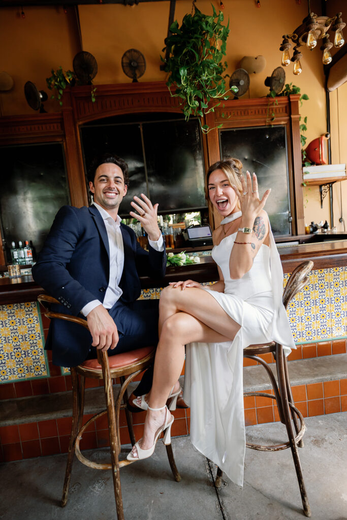 Bride and groom sitting at the bar at Habana in Irvine, California after their courthouse wedding.
