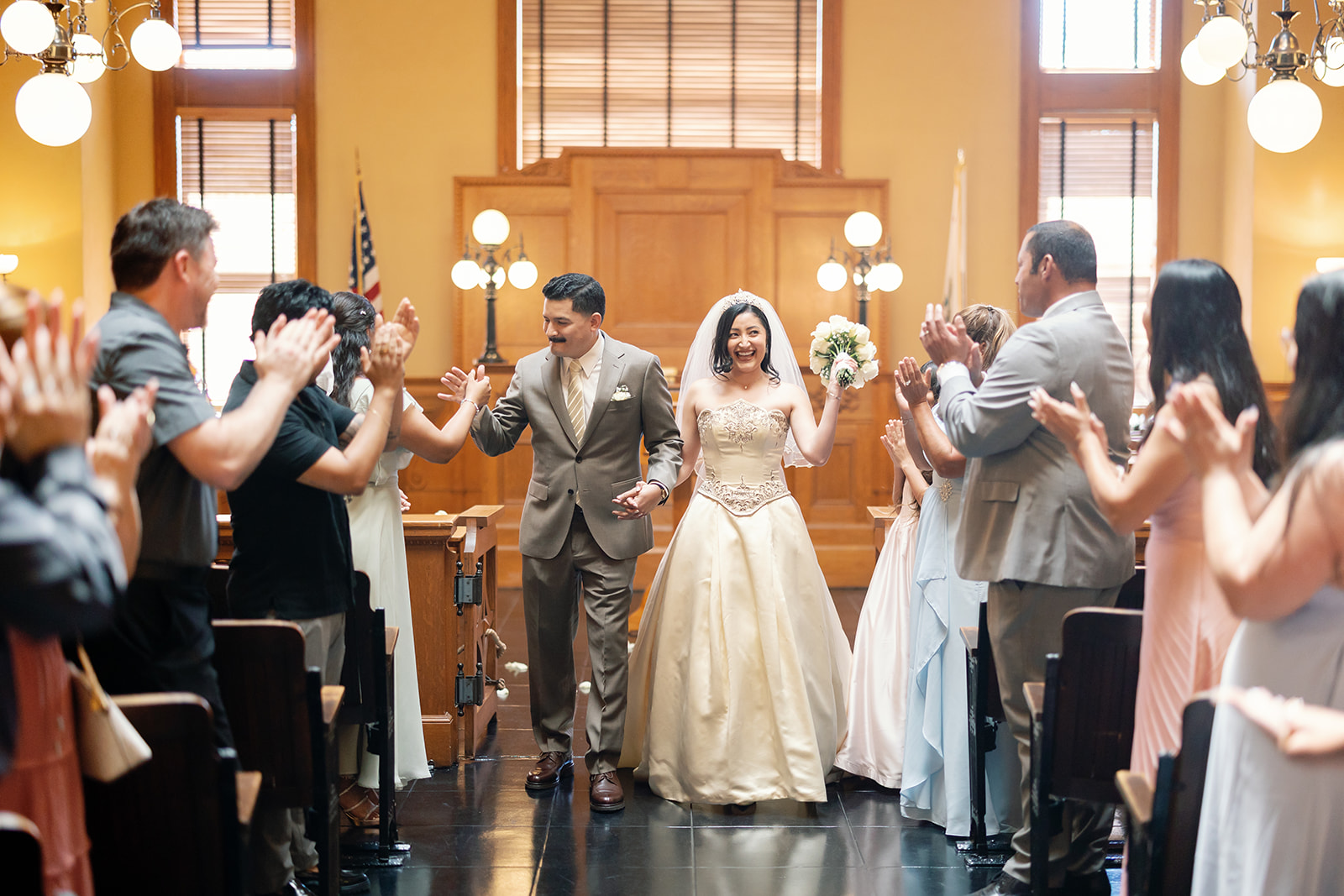 Bride and groom walking back down the aisle in the Historic Room after their Old Orange County Courthouse wedding in Santa Ana, California.