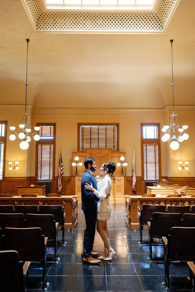 Bride and groom standing in the Historic Room for their Old Orange County Courthouse wedding in Santa Ana, California.