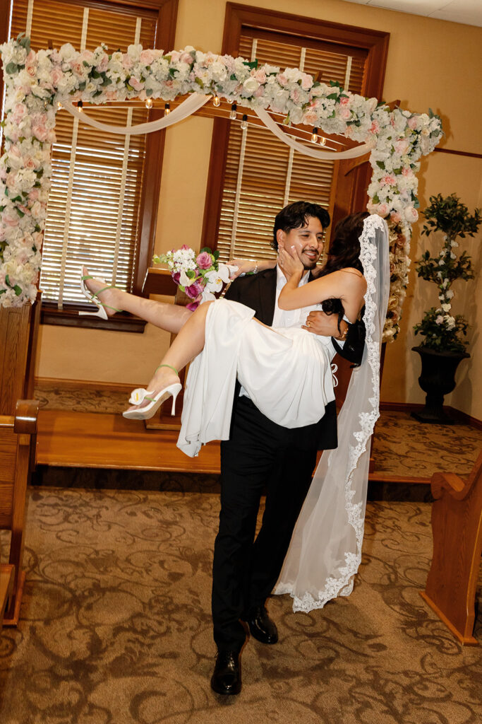 Groom carrying the bride back down the aisle.