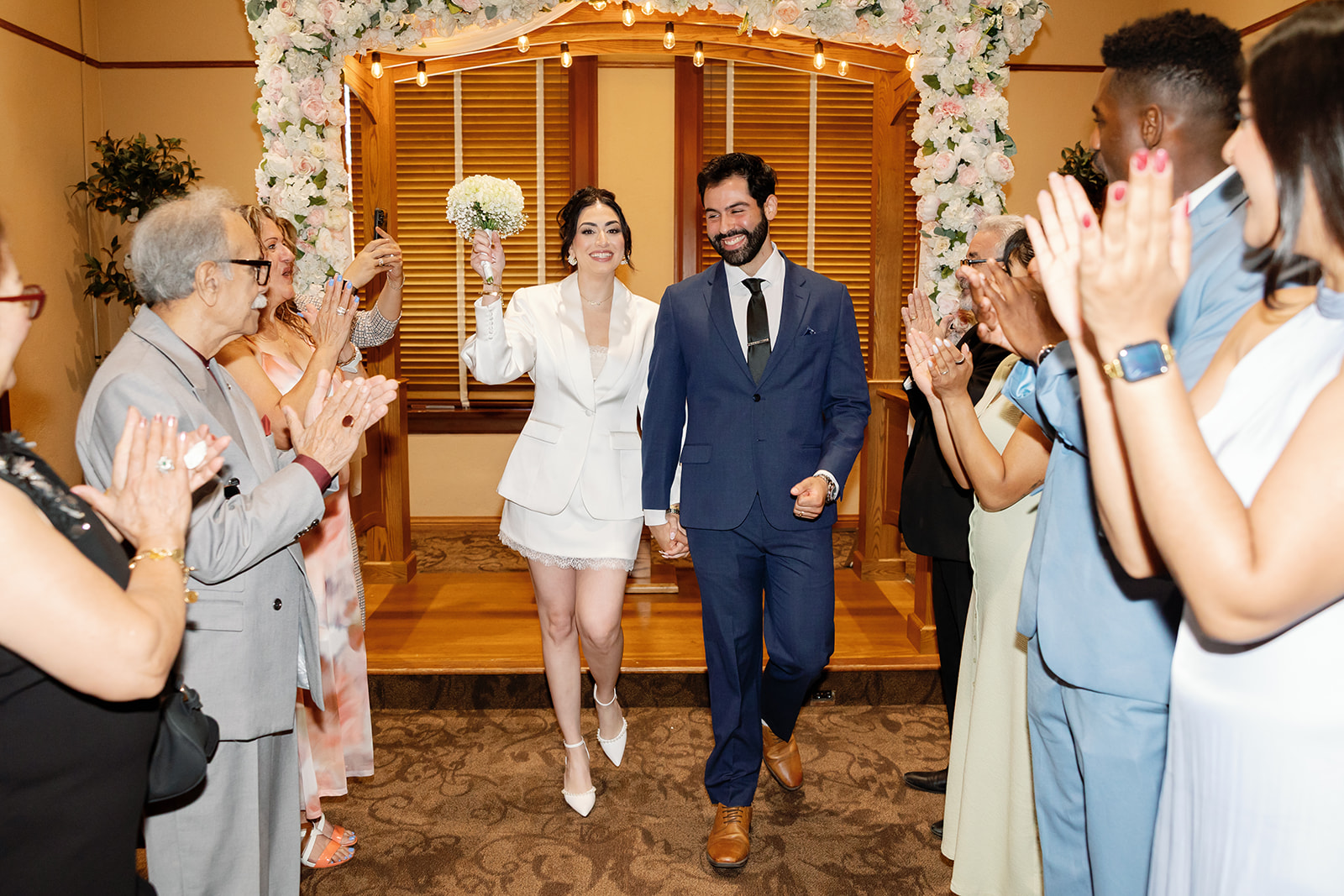 Bride and groom walking back down the aisle as husband and wife after their ceremony in Room A.