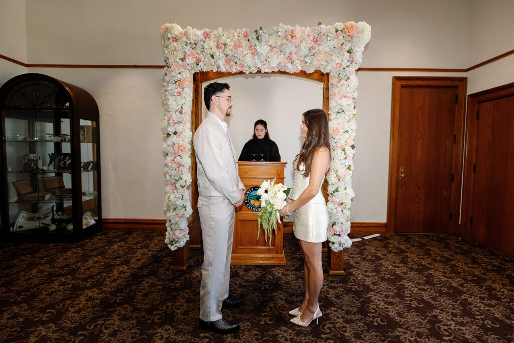 Bride and groom standing during their Old Orange County Courthouse wedding ceremony in Room B.