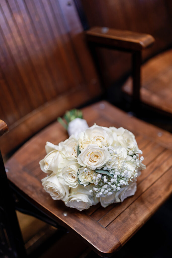 Brides wedding bouquet resting on a wooden chair inside the Historic Room.