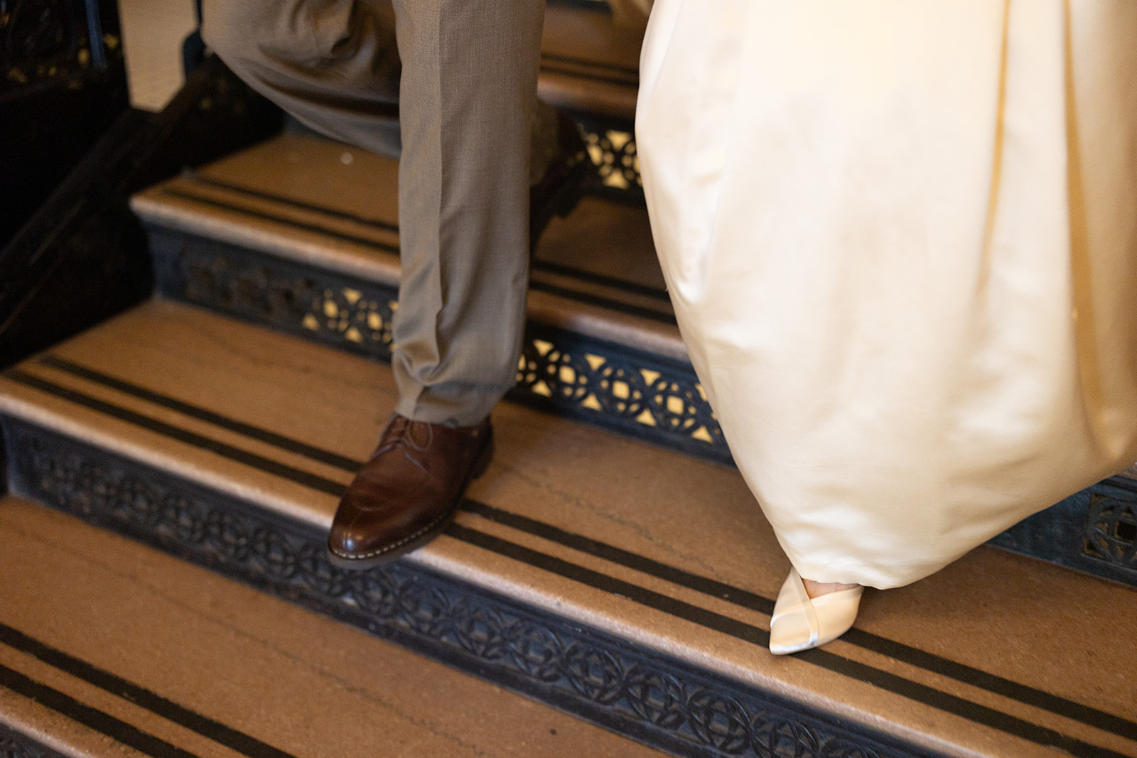 Close up shot of a bride and groom walking down the stairs.