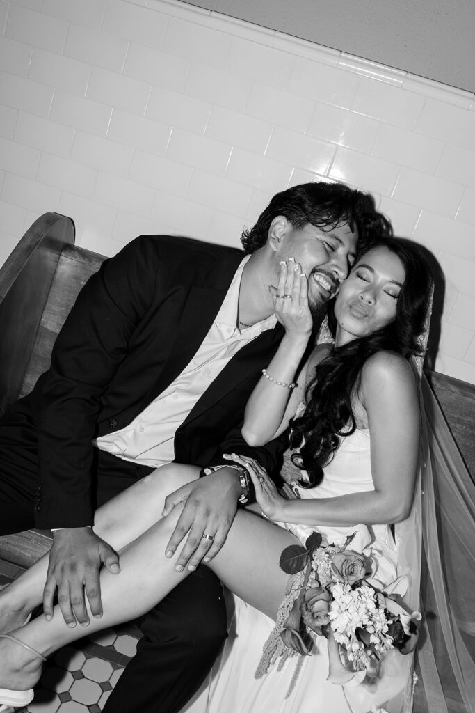 Black and white flash photo of a bride and groom posing for their Old Orange County Courthouse wedding photos in Santa Ana, California.