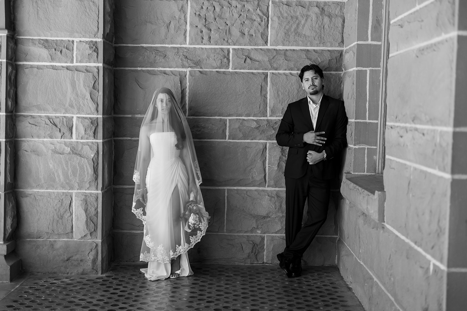 Black and white photo of a bride and groom posing at the Old Orange County Courthouse in Santa Ana, California.