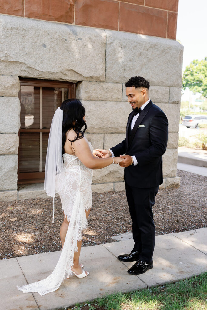 Bride and groom sharing a first look outside of the Old Orange County Courthouse in Santa Ana, California.