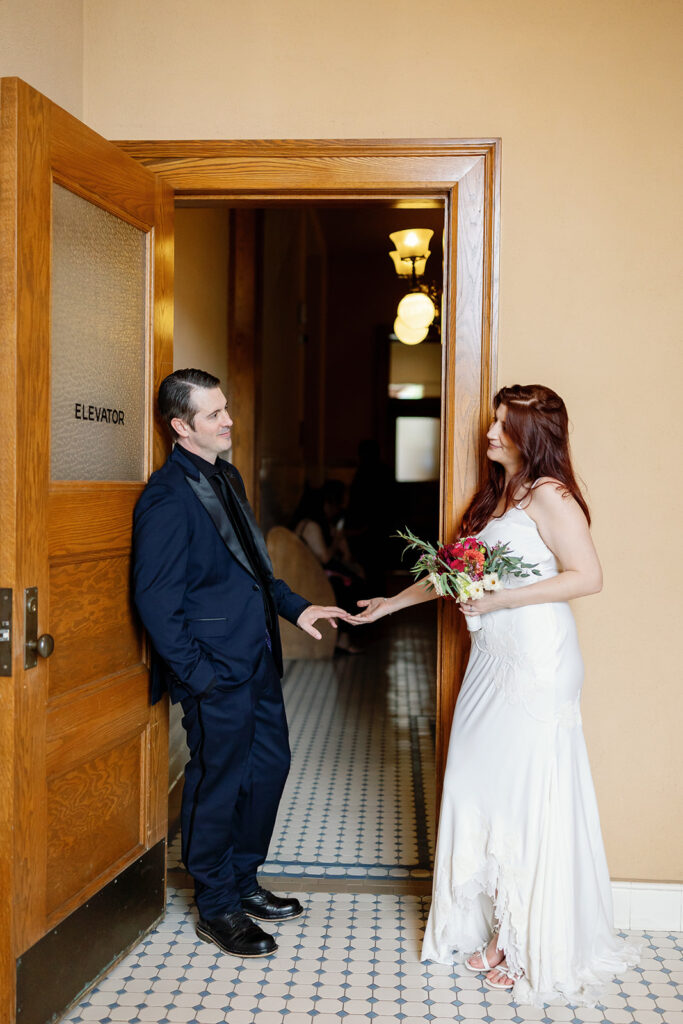 Bride and groom posing inside the Old Orange County Courthouse for their wedding photos in Santa Ana, California.
