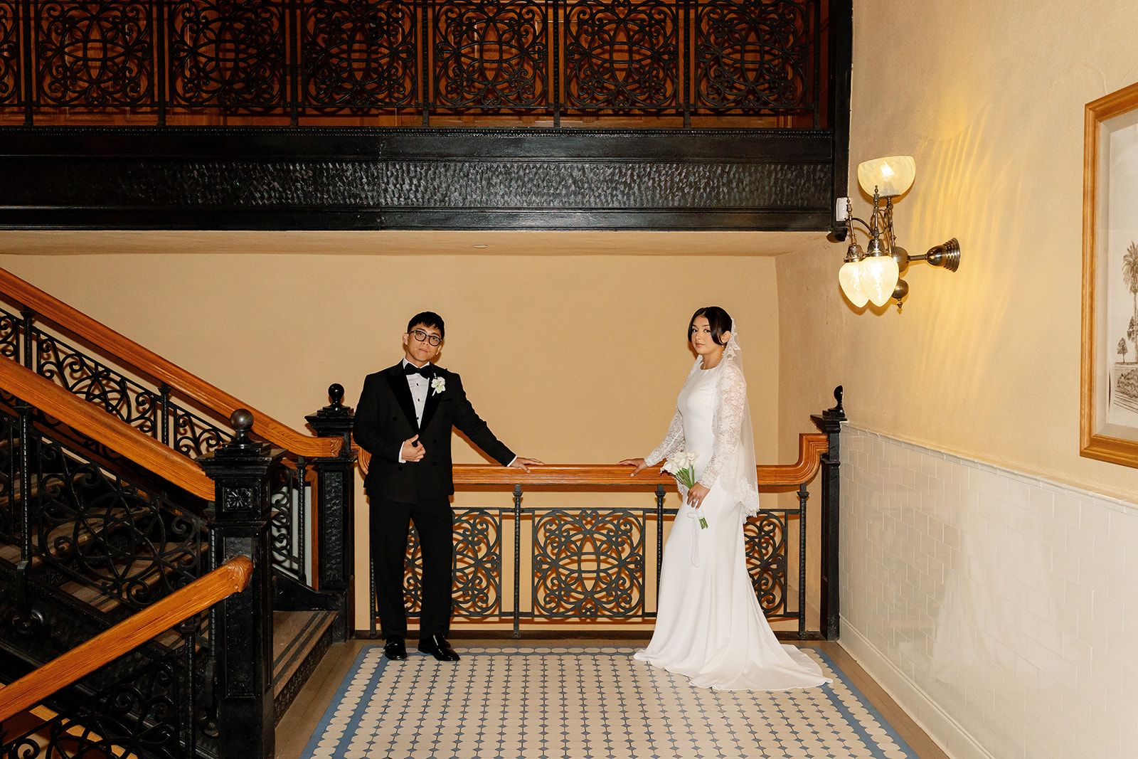 Bride and groom posing near the staircase at the courthouse.
