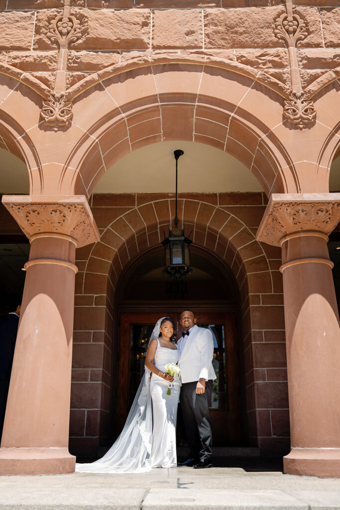 Bride and groom posing outside of the  Old Orange County Courthouse in Santa Ana, California.