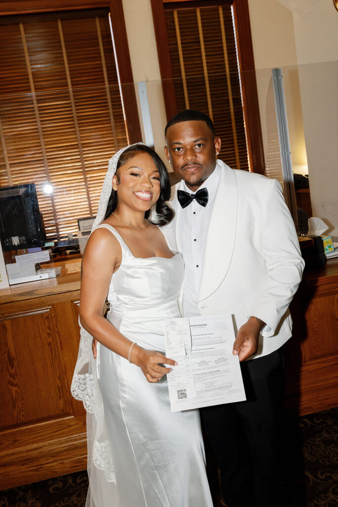 Bride and groom showing off their paperwork before their Old Orange County Courthouse wedding in Santa Ana, California.