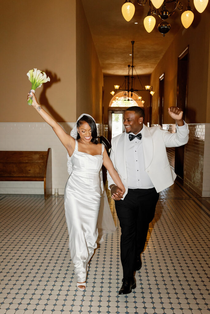 Flash photo of a bride and groom walking in the Old Orange County Courthouse in Santa Ana, California.