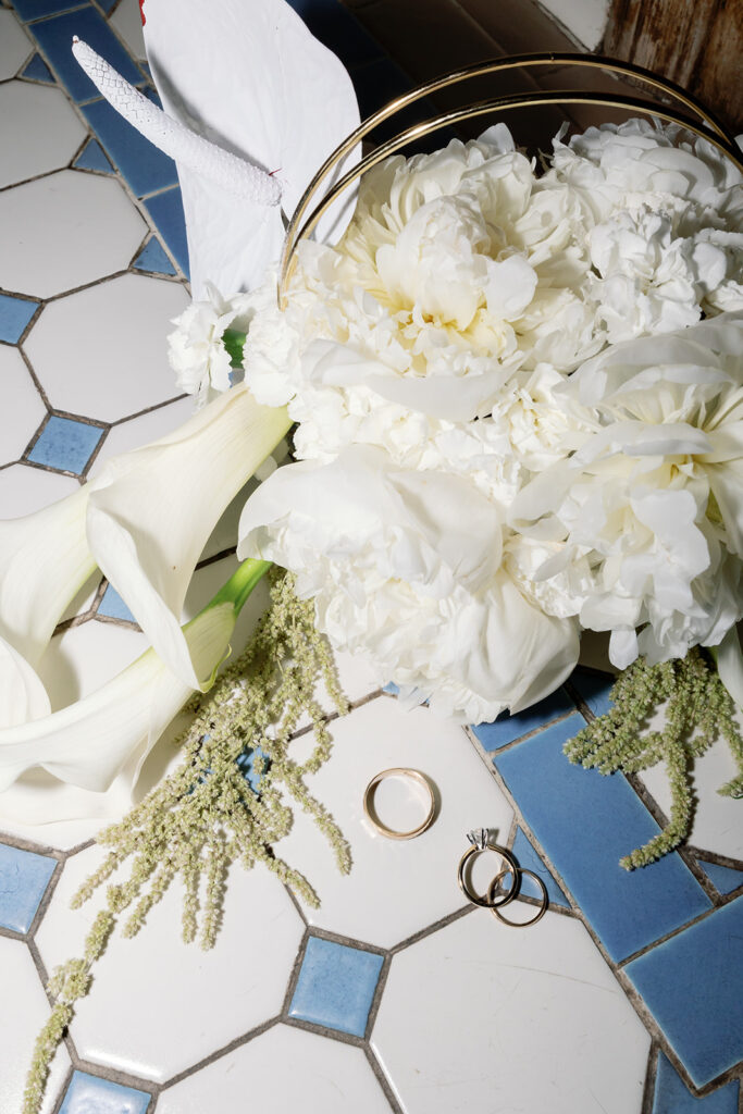 Wedding detail shot with a bouquet and rings.