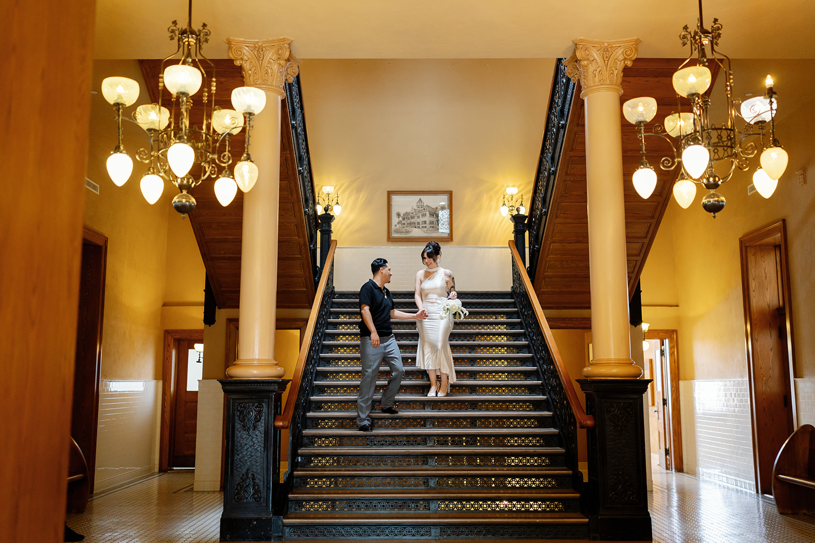 Bride and groom walking down the stairs at Old Orange County Courthouse in Santa Ana, California.