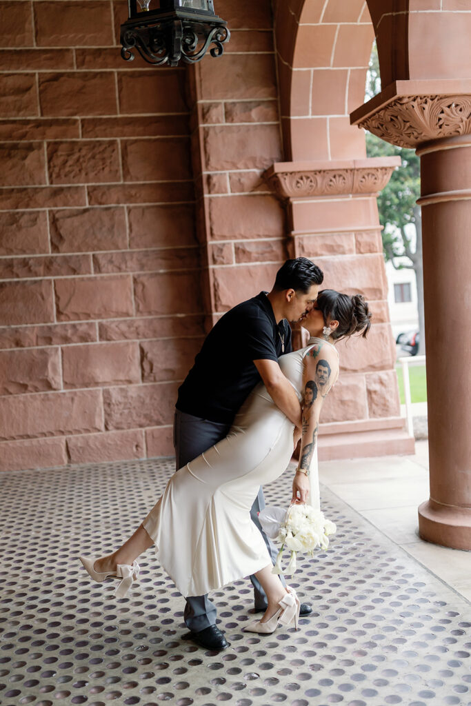 Bride and groom kissing at the Old Orange County Courthouse in Santa Ana, California.
