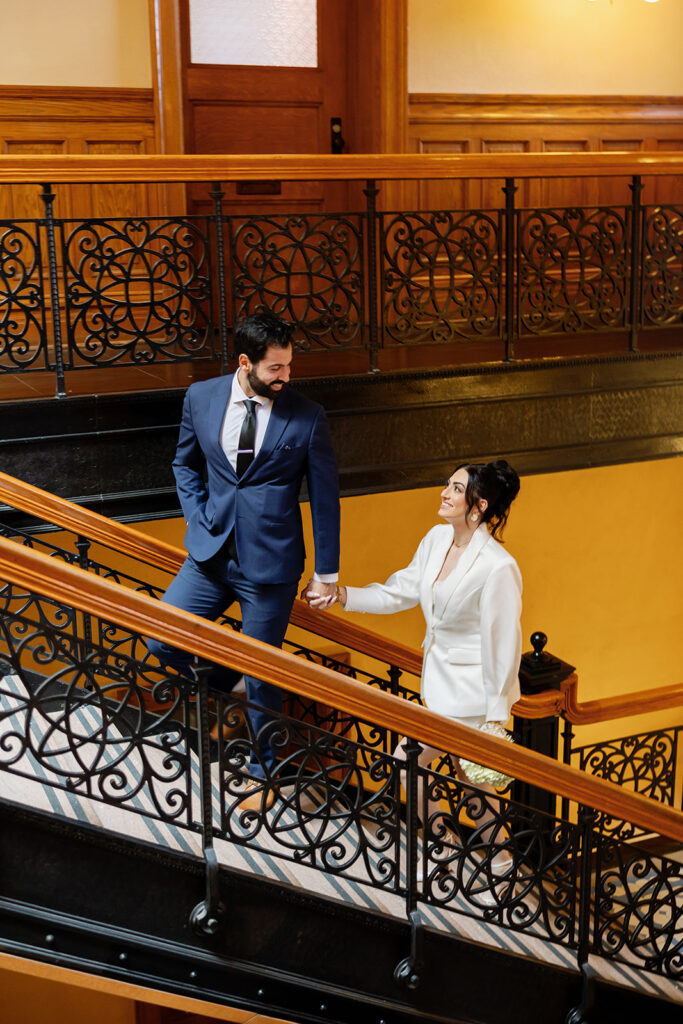 Bride and groom walking up the historic staircase for their Old Orange County Courthouse wedding photos in Santa Ana, California.